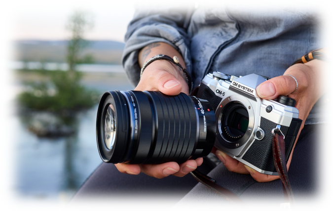 Billede af fotograf der er ved at skifte objektiv p&aring; et OM 5 kamera