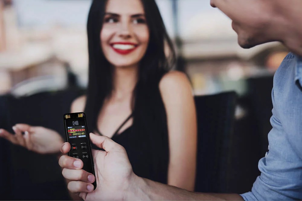 Billede af mand der holder diktafon mens han interviewer kvinde