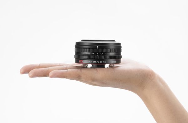 Hånd der holder Viltrox AF 26mm 2,8 EVO til Sony E kamera