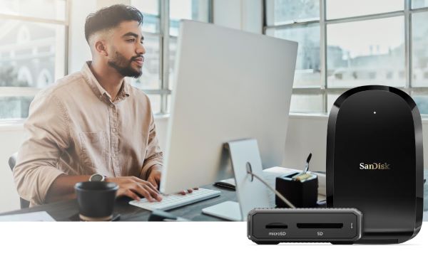 Billede af person foran Mac compuper og med 2 Sandisk kortl&aelig;sere i forgrunden