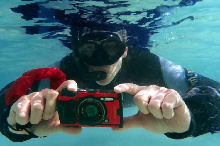billede af snorkeldykker der fotografferer under van med et OM System TG-6 kamera